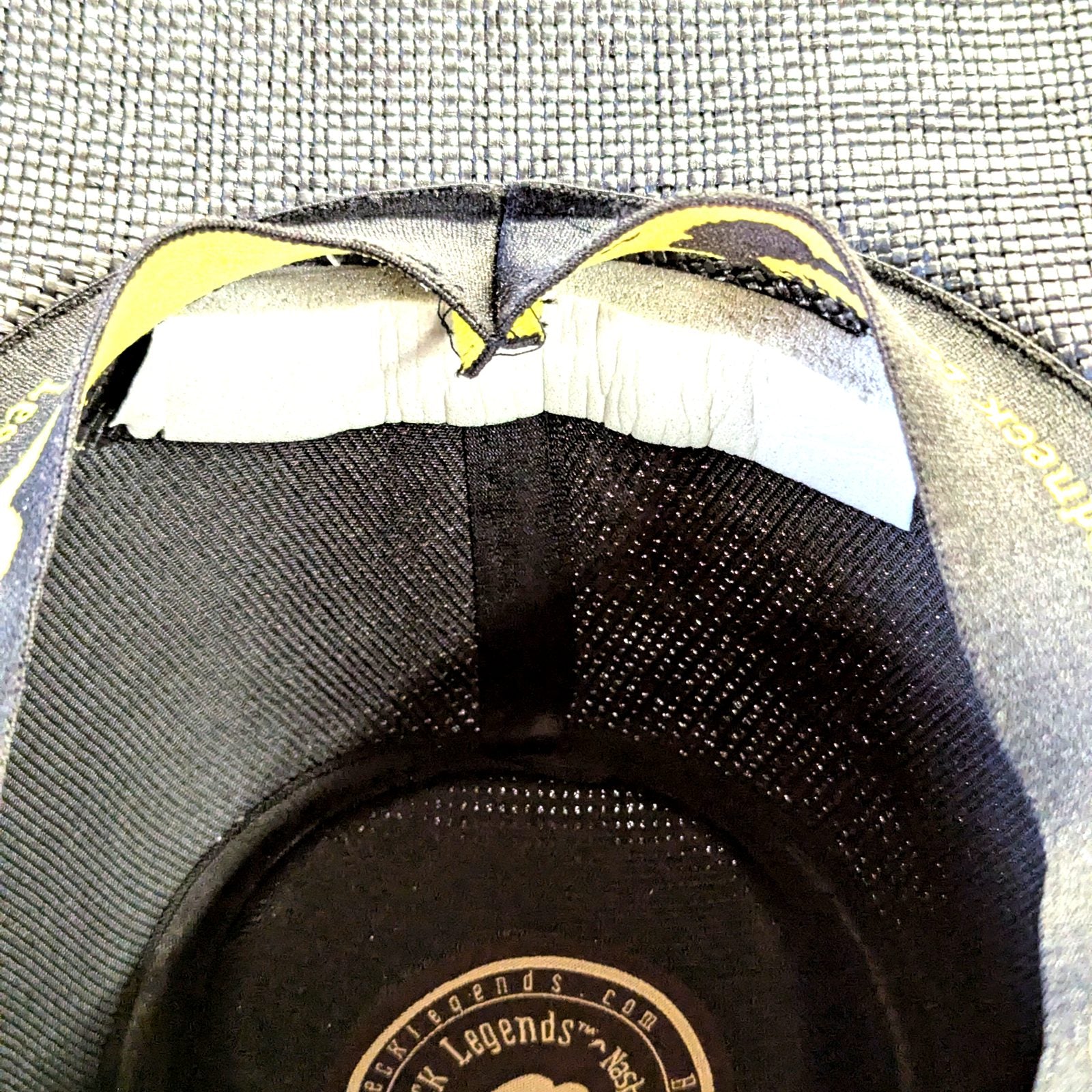 Grey hat sizing foam strip installed under the sweatband of a Redneck Legends cowboy hat — closeup of the peel-and-stick fit fix