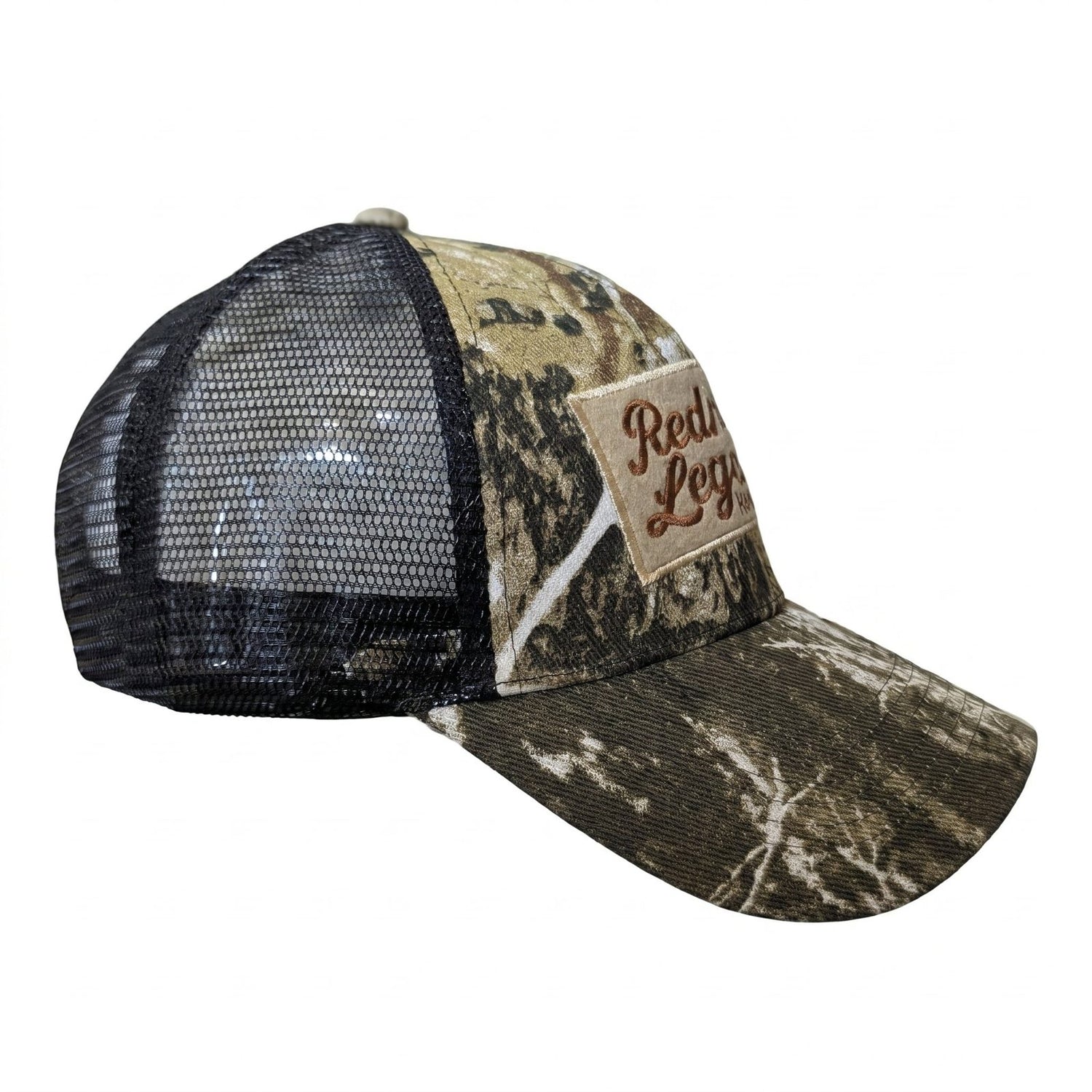 Camo Trucker Hat by Redneck Legends — angled view showing the woodland camo front, embroidered Nashville patch, black mesh side panel, and curved camo bill.
