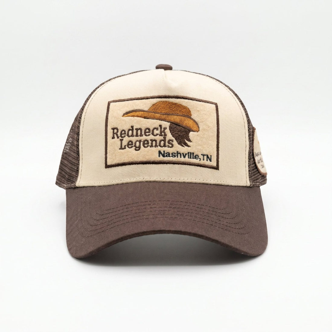 Redneck Legends Cream &amp; Brown Trucker Hat — front view, cream crown with embroidered cowboy hat and mullet logo patch, brown brim