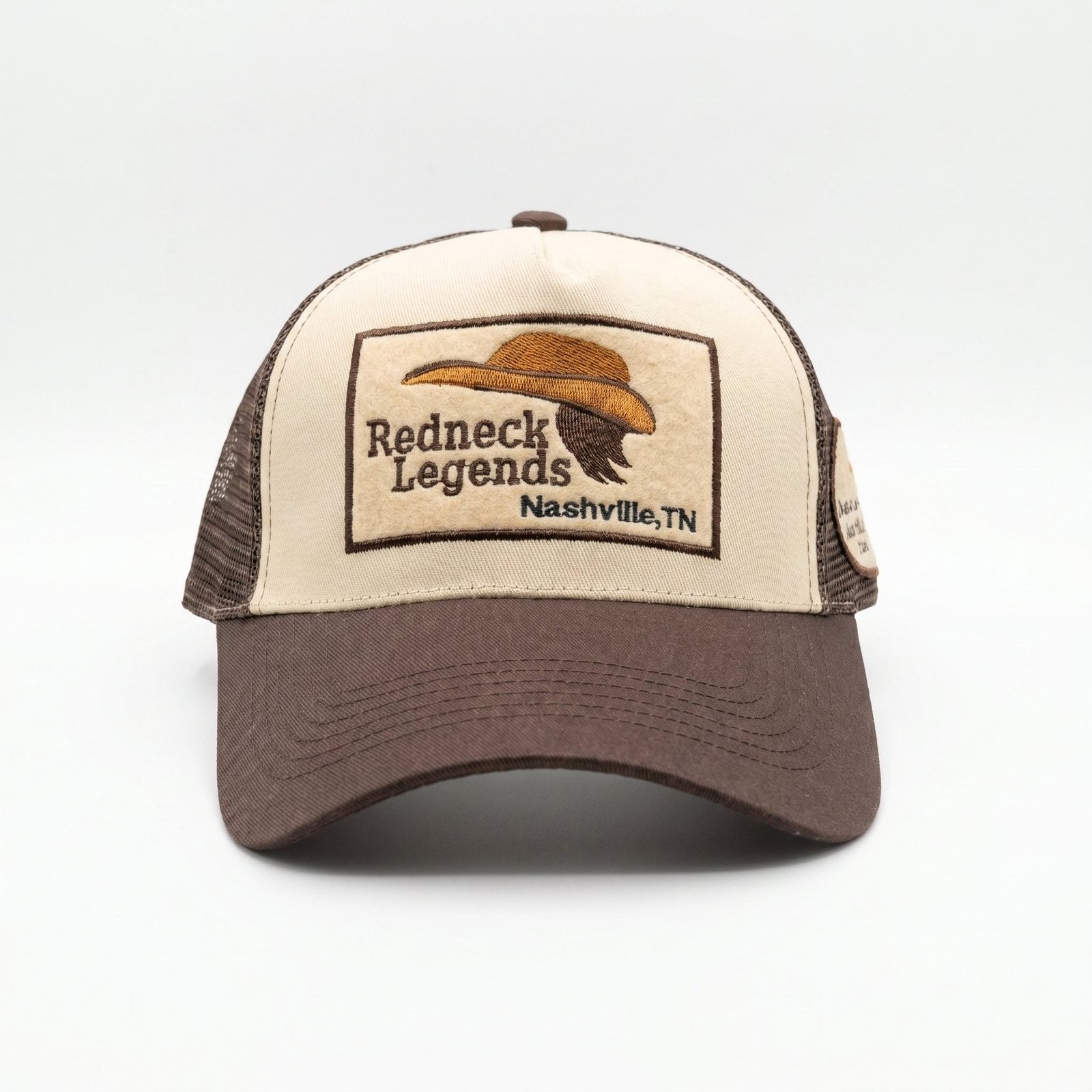 Redneck Legends Cream &amp; Brown Trucker Hat — front view, cream crown with embroidered cowboy hat and mullet logo patch, brown brim