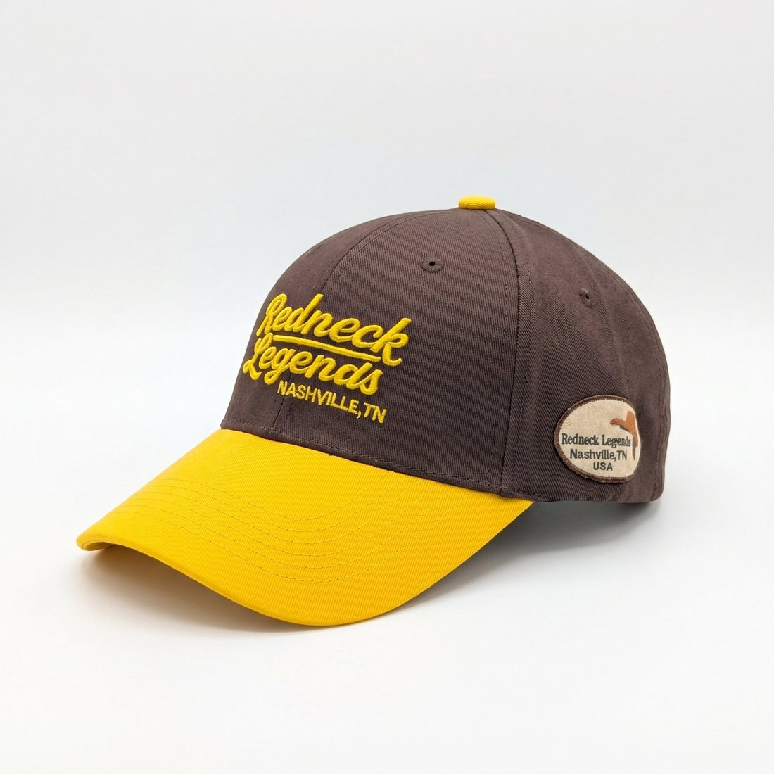 Brown &amp; Gold Snapback Cap by Redneck Legends — angled view showing the gold front embroidery, golden-yellow bill, and the woven oval Nashville side patch.