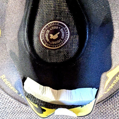 Hat sizing foam strip in place along the sweatband inside a Redneck Legends cowboy hat, branded interior patch visible
